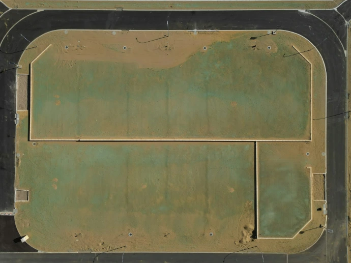 Aerial view of a dusty, green athletic field.